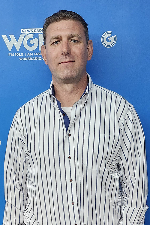 Rick Neff, commercialization counselor at MTSU, standing in front of a blue backdrop at the WGNS Radio studio.