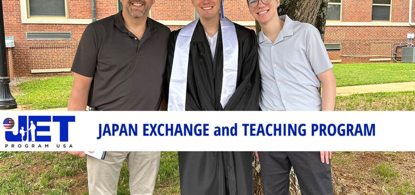 Tristan Howard posing with two other males outside campus building.