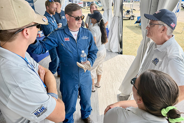 Members of the United Kingdom’s Royal Air Force’s flight demonstration team, the Red Arrows, visited with Middle Tennessee State University Provost Mark Byrnes, right, and students from MTSU’s Aerospace Department at the university’s tent at the July 2026 EAA AirVenture in Oshkosh, Wis. (MTSU Photo by Andrew Oppmann)