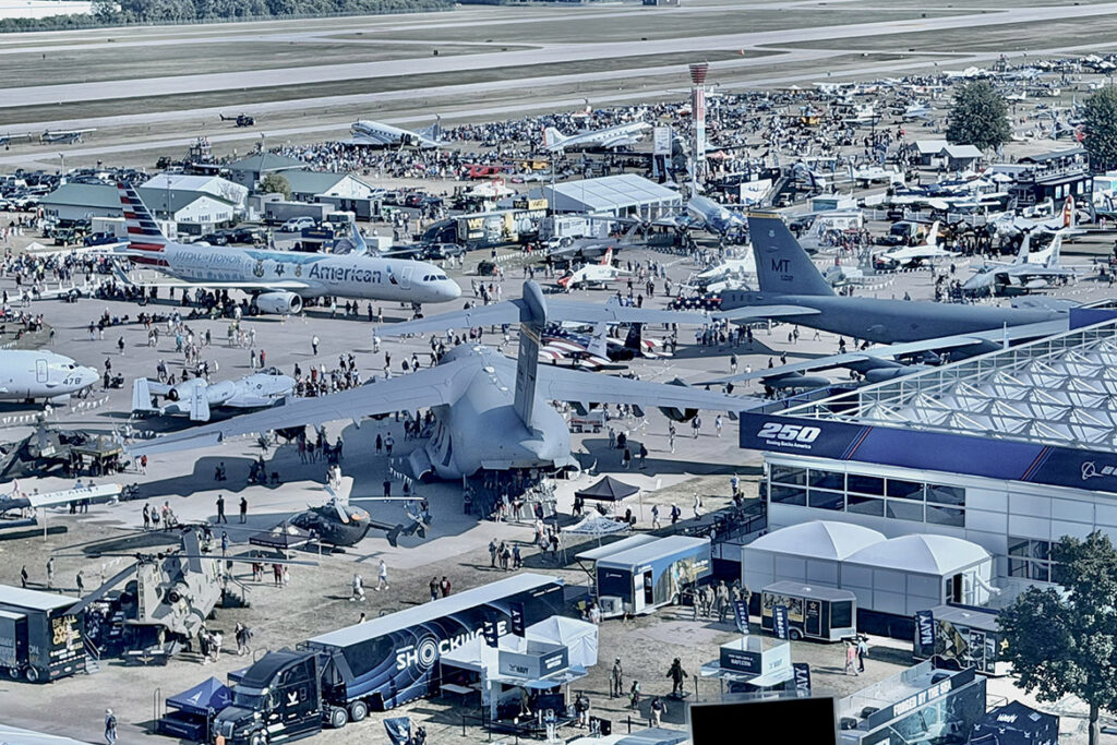 With planes of various shapes and sizes on display, attendees mill about Boeing Plaza during the July 2026 EAA AirVenture in Oshkosh, Wis. (MTSU Photo by Andrew Oppmann)
