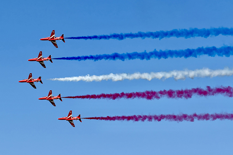 United Kingdom’s Royal Air Force’s flight demonstration team, the Red Arrows, emit multicolored smoke trails from their aircraft as they perform during the July 2026 EAA AirVenture in Oshkosh, Wis. (MTSU Photo by Andrew Oppmann)