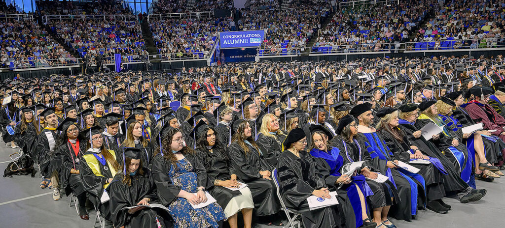 Wide shot of hundreds of MTSU graduates seated inside Murphy Center.