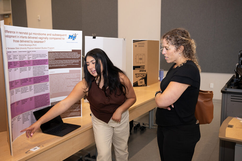 Viviana Bocanegra, left, a Physician Assistant Studies student at Middle Tennessee State University in Murfreesboro, Tenn., talks to physician assistant Katie Marcucci about her final class project on display at the 2025 Capstone and Poster Symposium. This year’s event — when Bocanegra will give her final research presentation as a second-year student — is 11:30 a.m. to 4:30 p.m. Friday, July 31, in the Academic Classroom Building, 1751 MTSU Blvd. (MTSU file photo by James Cessna)
