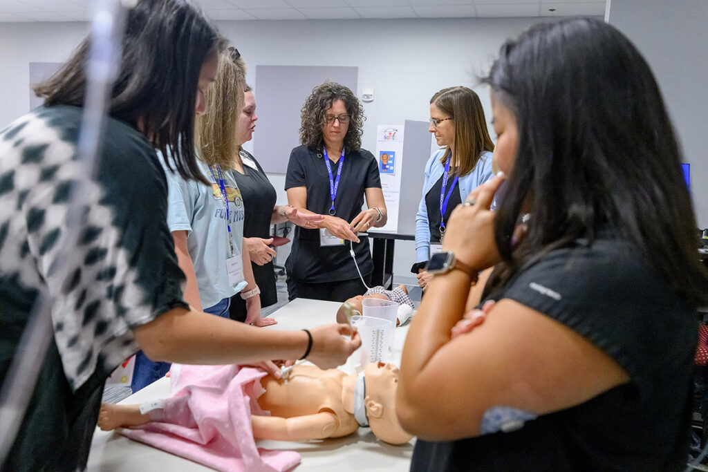 Rutherford County Schools nurses Stephanie Nipper, center, and Kathy Myers, to her right, are among the school nurses practicing tube feeding on a high-fidelity mannequin at the School Nurse Skills Day hosted in June at Middle Tennessee State University School of Nursing in Murfreesboro, Tenn. (MTSU photo by J. Intintoli)