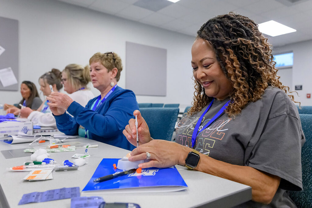 A group of nurses from school districts across the Midstate practices giving a dose of insulin on a simulated injection pad during the School Nurse Skills Day hosted in June at Middle Tennessee State University School of Nursing in Murfreesboro, Tenn. (MTSU photo by J. Intintoli)