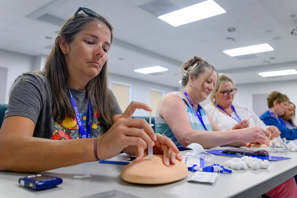 A group of nurses from school districts across the Midstate practices giving a dose of insulin on a simulated injection pad during the School Nurse Skills Day hosted in June at Middle Tennessee State University School of Nursing in Murfreesboro, Tenn. (MTSU photo by J. Intintoli)