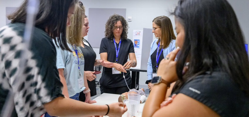 Rutherford County Schools nurses Stephanie Nipper, center, and Kathy Myers, to her right, are among the school nurses practicing tube feeding on a high-fidelity mannequin at the School Nurse Skills Day hosted in June at Middle Tennessee State University School of Nursing in Murfreesboro, Tenn. (MTSU photo by J. Intintoli)