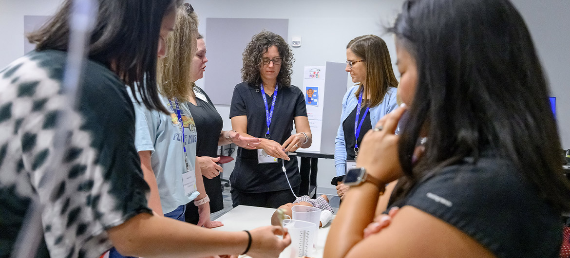 Rutherford County Schools nurses Stephanie Nipper, center, and Kathy Myers, to her right, are among the school nurses practicing tube feeding on a high-fidelity mannequin at the School Nurse Skills Day hosted in June at Middle Tennessee State University School of Nursing in Murfreesboro, Tenn. (MTSU photo by J. Intintoli)