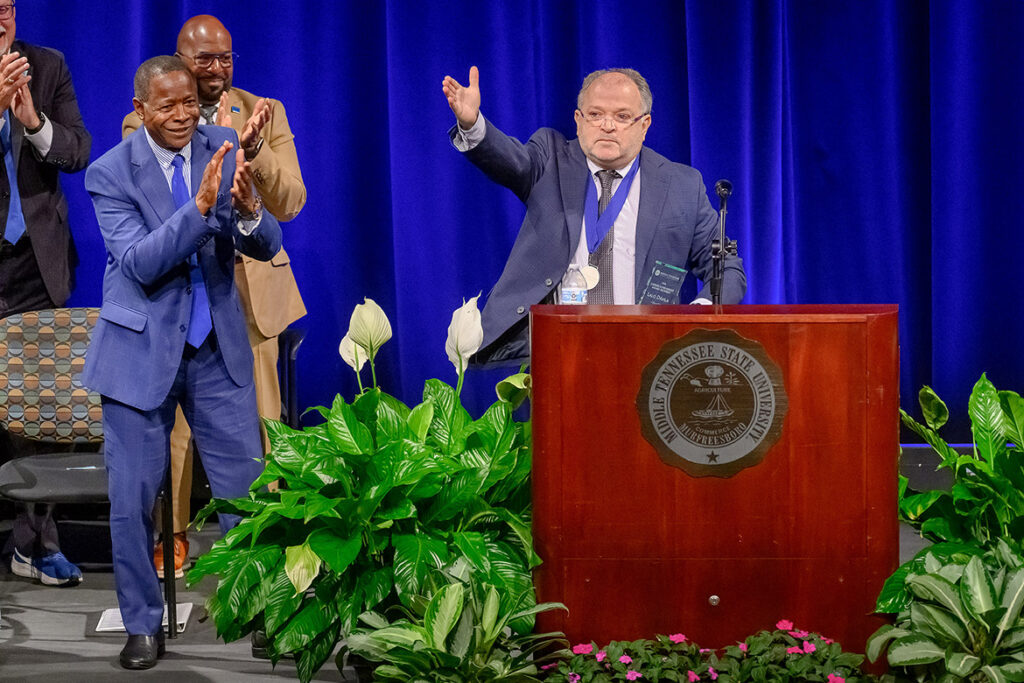 Lalo Davila, professor of music and director of percussion studies at Middle Tennessee State University in Murfreesboro, Tenn., gestures to the crowd gathered on campus Thursday, Aug. 20, in Tucker Theatre after receiving the 2026 Career Achievement Award from the MTSU Foundation during the annual Fall Faculty and Staff Meeting. Davila, an award-winning percussionist who has traveled the world, has spent the last 40 years as an educator at MTSU. (MTSU photo by Andy Heidt)