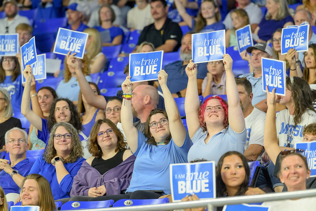 Surrounded by friends and family, new Middle Tennessee State University students hold up “I Am True Blue” signs during the 25th annual Convocation ceremony held Saturday, Aug. 22, in Murphy Center on campus in Murfreesboro, Tenn. (MTSU photo by Andy Heidt)