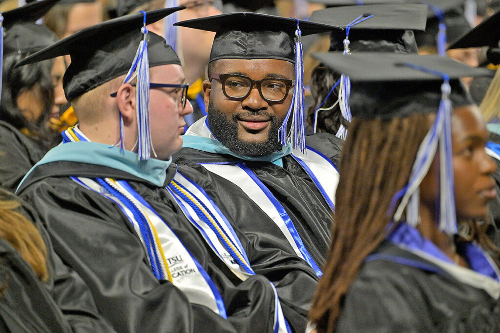 Middle Tennessee State University graduate students Jared McGee, left, and Michai Mosby await their turn to receive their master’s degrees during the summer commencement ceremony on Saturday, Aug. 8, 2026, inside Murphy Center on campus. (MTSU photo by Andy Heidt)