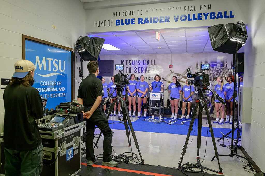 Alexa Keckler, women’s volleyball coach at Middle Tennessee State University in Murfreesboro, Tenn., stands with her team as she speaks to the crowd of administrators, alumni, military veterans, staff and students gathered on Wednesday, Sept. 2, 2026, for the unveiling of the new World War II Memorial located in Alumni Memorial Gym just outside the volleyball court. The gym was named in honor of veterans who lost their lives in World War II. (MTSU photo by J. Intintoli)