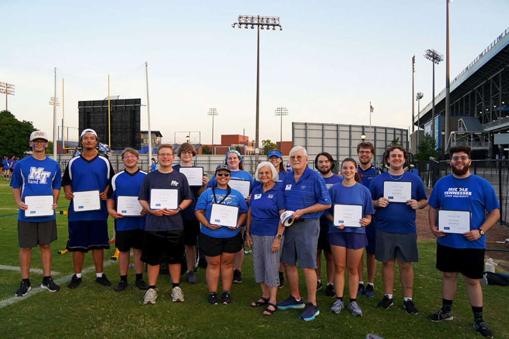 Don and Hanna Witherspoon, front center, pose with Middle Tennessee State University Band of Blue students on Aug. 21, 2026, just outside the football and baseball stadiums on campus in Murfreesboro, Tenn. The students received scholarships during the final evening of band camp. The Witherspoons were among donors to the “Where Every Note Counts” campaign invited to meet scholarship recipients and see firsthand the impact of their support. (MTSU photo by Mike Davis) 