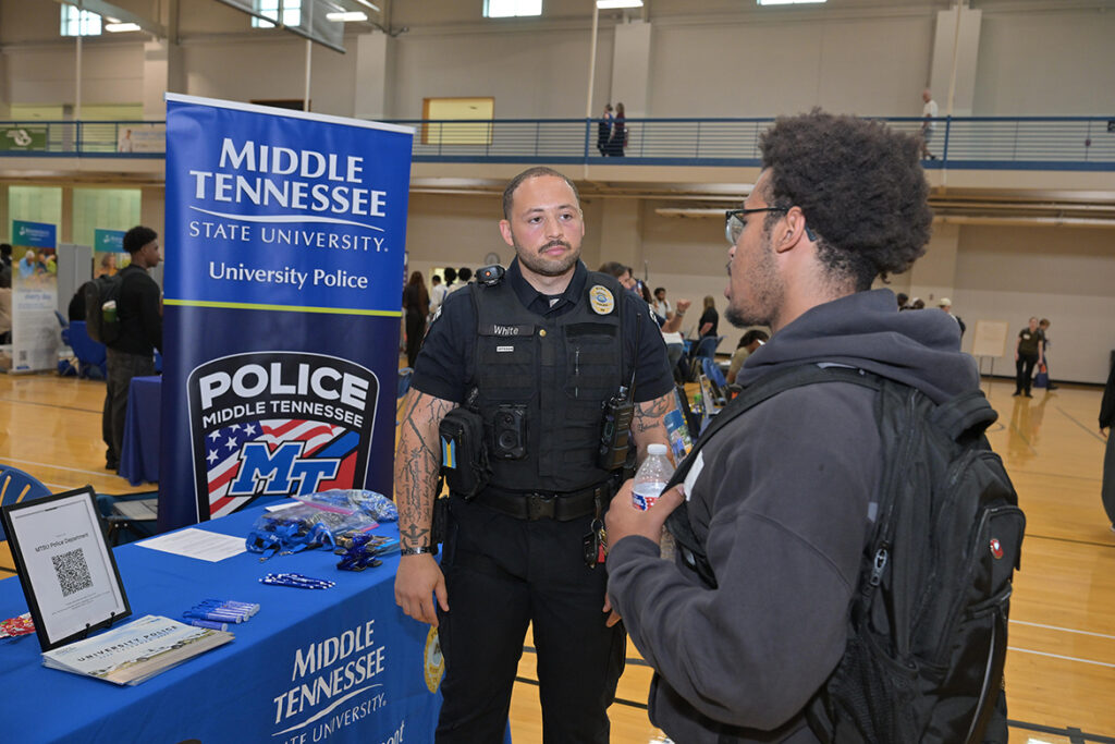 Bentley White, center, a patrol officer with the Middle Tennessee State University Police Department, speaks with a student who stopped at his recruitment booth at the annual Big Career Fair on Thursday, Sept. 24, 2026, in the Campus Recreation Center in Murfreesboro, Tenn. (MTSU photo by James Cessna)