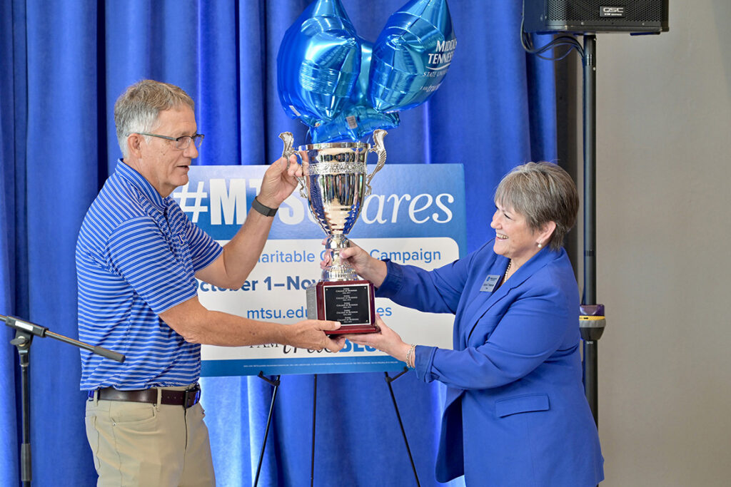 Joyce Heames, right, dean of the Jennings A. Jones College of Business at Middle Tennessee State University in Murfreesboro, Tenn., relinquishes the Provost Cup to Provost Mark Byrnes during the kickoff of the 2026-27 Employee Charitable Giving Campaign in mid-September in the Cope Administration Building lobby. The Jones College has won the cup for more than a decade straight as the academic unit with the highest percentage of givers. (MTSU photo by J. Intintoli).