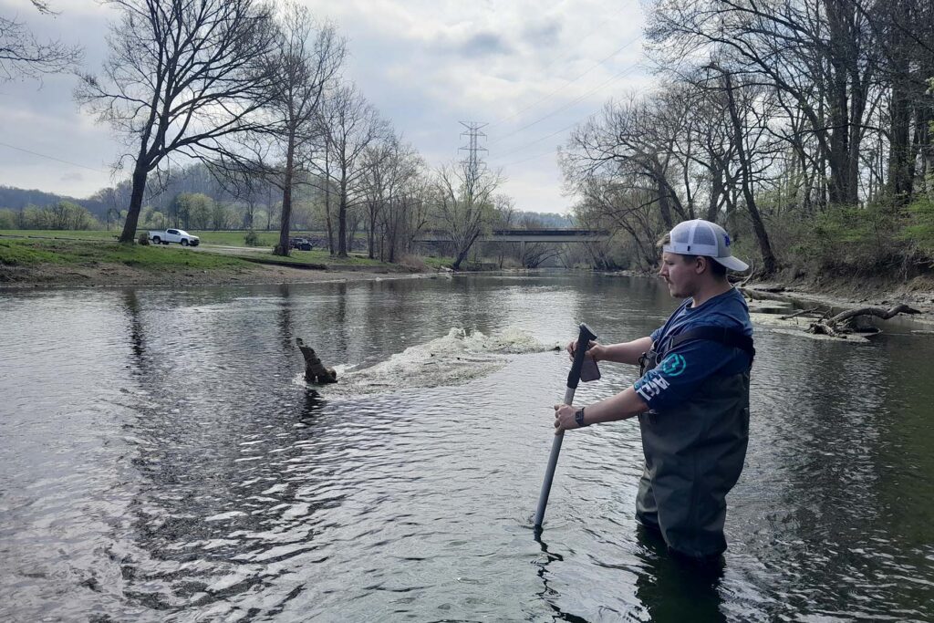 Ronald Griffin, an undergraduate student from the Department of Geosciences at Middle Tennessee State University in Murfreesboro, Tenn., measures stream velocity below the spillway at Normandy Dam in Normandy, Tenn., to help estimate flow conditions and sediment transport in this portion of the Duck River, one of the most biologically diverse freshwater rivers in North America. (Submitted photo)