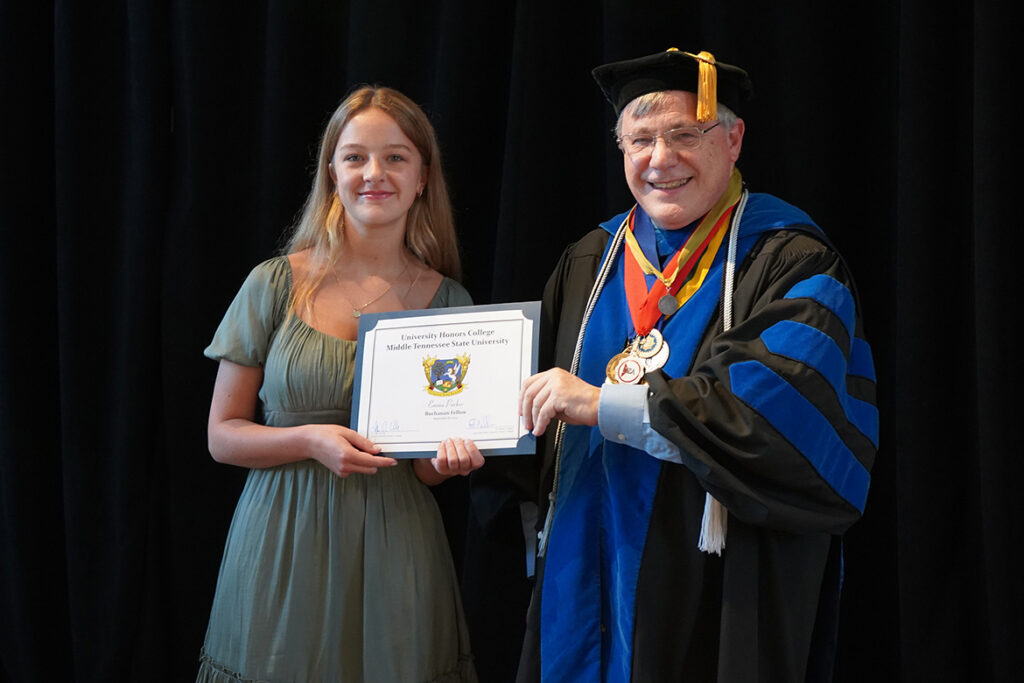 In this undated photo, Emma Parker, left, a music major at Middle Tennessee State University in Murfreesboro, Tenn., accepts a Buchanan Fellow certificate from Honors College Dean John Vile. (MTSU photo by Robin E. Lee)