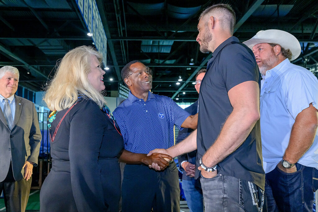 Middle Tennessee State University President Sidney A. McPhee, center, shakes hands with Pat Pollifrone, lead singer for rising country act Miller Holler, during the Live at MTSU concert series press conference held Tuesday, Sept. 8, 2026, inside Murphy Center on campus in Murfreesboro, Tenn. Holler will be part of the artist lineup for the first concert on Nov. 5, featuring headliner and multi-platinum country artist Bailey Zimmerman along with hip-hop artist Waka Flocka Flame, and DJ/producer Dee Jay Silver. Left of McPhee is Carri Hyde, founder and CEO of concert presenter NVRDUL Events. (MTSU photo by J. Intintoli)