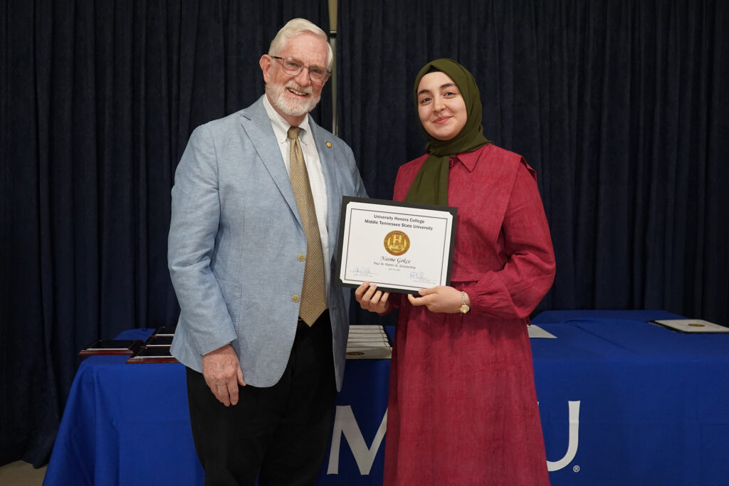 In this undated photo, Naime Gokce, right, a biochemistry major at Middle Tennessee State University in Murfreesboro, accepts a certificate from Paul W. Martin Jr.