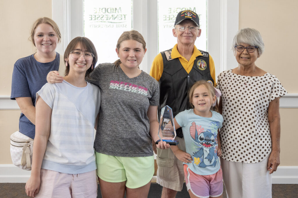 United States Air Force veteran “Mobile Phil” LaPrad, third from right, poses with family members after receiving the 2026 Joe Nunley Distinguished Veteran Award at the Veterans Memorial Service held Saturday, Sept. 19, 2026, inside the Tom H. Jackson Building at Middle Tennessee State University in Murfreesboro, Tenn. Pictured with him, from left, are daughter-in-law Molly, granddaughters Elle and Kaori, granddaughter Layla and spouse, Yuki LaPrad, The Nunley Award celebrates the career of World War II U.S. Army veteran and MTSU alum Joe Nunley Sr. and is presented each year as part of the Salute to Veterans and Armed Services activities hosted by the Charlie and Hazel Daniels Veterans and Military Families Center. (MTSU Photo by Cat Curtis Murphy)