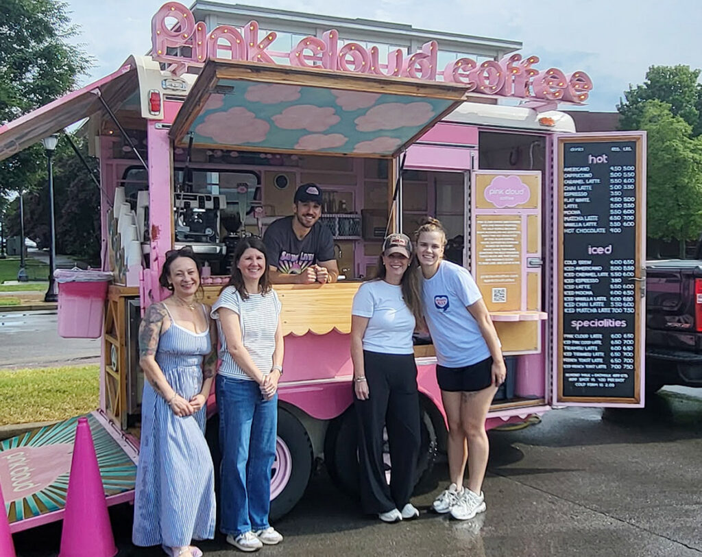 Pink Cloud Coffee truck owner Dalton Deutsch, center, serves up drinks on campus at Middle Tennessee State University in Murfreesboro, Tenn., on Aug. 21, 2026, during move-in weekend to raise awareness for True Blue Peers 4 Success student recovery group in partnership with Prevention Coalition for Success. Pictured with Deutsch are, front, from left, Kristi Stringer, assistant professor of public health and faculty sponsor for the group; Prevention Coalition Director Sarah Murfree and colleagues Katherine Prince and Morgan Verdeck, event organizers with the Coalition. (Submitted photo)