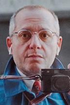 Ray DiPetro, photojournalist, holding camera.