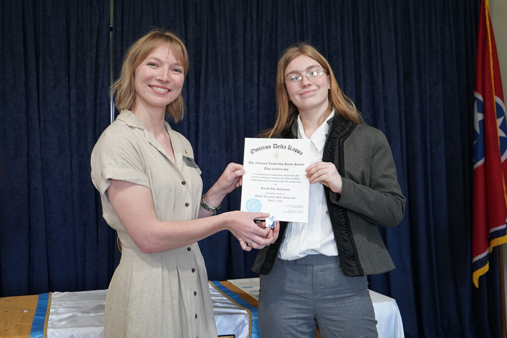 Nancy Prescott, left, coordinator of student engagement in the Honors College at Middle Tennessee State University in Murfreesboro, Tenn., presents Buchanan Fellow Sarah Holzmann with a pin and certificate of initiation into the MTSU Circle of Omicron Delta Kappa honor society in spring 2026. (MTSU photo by Robin E. Lee).