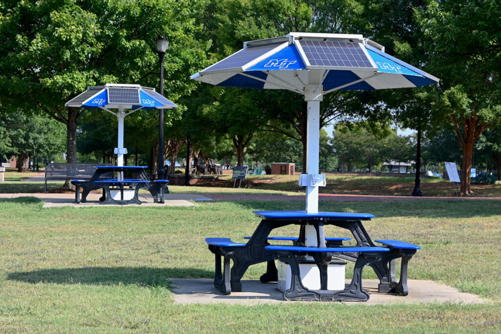 Two solar-powered picnic tables with canopies outdoors.