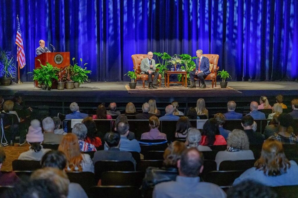 Middle Tennessee State University Board of Trustees Chairman Steve Smith sits at the podium on stage at Tucker Theatre on campus in Murfreesboro, Tenn., as former U.S. Sens. Lamar Alexander, seated at left, and Dr. Bill Frist talk on the topic of “Leadership and Public Service” during a conversational lecture on Monday, Oct. 19, presented by the MTSU American Democracy Project as part of the America 250 celebrations happening throughout the year to celebrate the United States semiquincentennial. (MTSU photo by J. Intintoli)