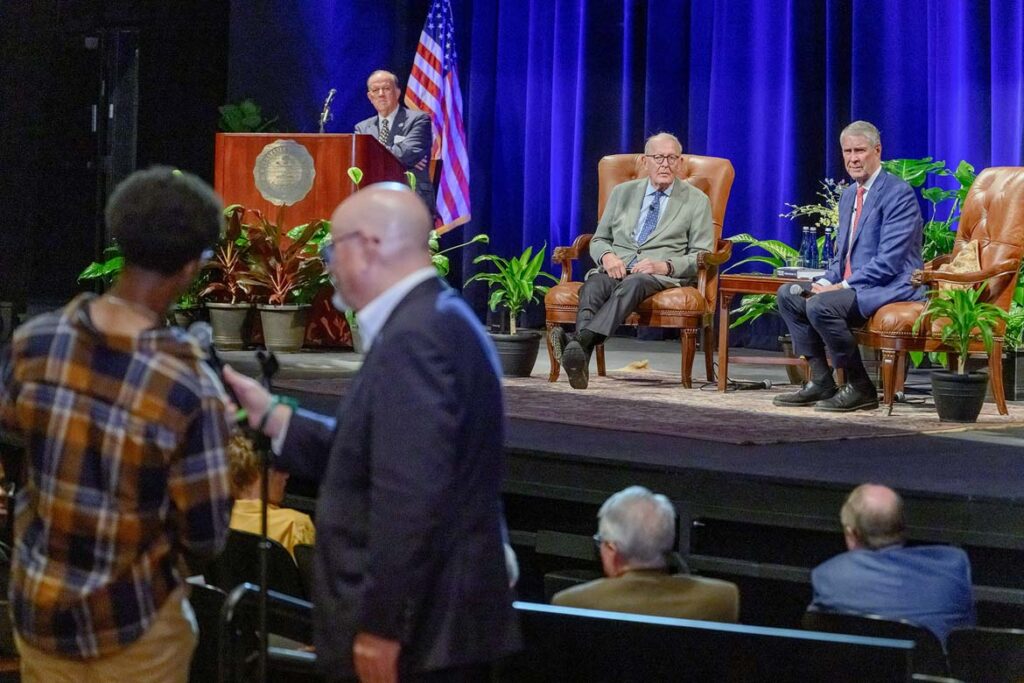 Middle Tennessee State University Board of Trustees Chairman Steve Smith listens at the podium on stage, as Andrew Oppmann, vice president of Marketing and Communications at Middle Tennessee State University in Murfreesboro, Tenn., holds a microphone for MTSU student journalist Gary Davis, who is posing questions for former U.S. Sens. Lamar Alexander, seated at left, and Dr. Bill Frist, following a conversational lecture on the topic of “Leadership and Public Service” held Monday, Oct. 19, inside Tucker Theatre on campus. (MTSU photo by J. Intintoli)