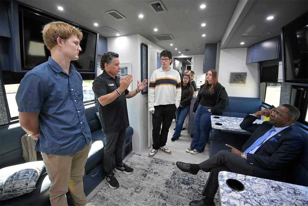 Middle Tennessee State University President Sidney A. McPhee, right, and a group of students listens as Eric Blankenship, second from left, co-owner of Gallatin-based All Access Coach Leasing, gives a tour of one of his company’s buses he brought to the parking lot of the Miller Education Center on Bell Street on campus in Murfreesboro, Tenn. Blankenship visited campus on Tuesday, Oct. 6, 2026, as part of the announcement of a $250,000 donation by his company to MTSU’s Center for Student Coaching and Success. (MTSU photo by Andy Heidt).