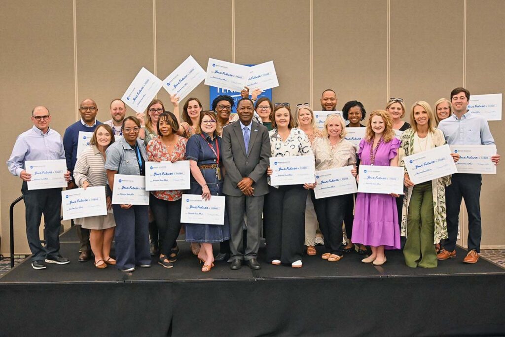 Sidney A. McPhee, center, president of Middle Tennessee State University in Murfreesboro, Tenn., stands with high school guidance counselors and community college representatives who are holding their $1,000 scholarship checks during the True Blue Tour recruitment luncheon held on Wednesday, Oct. 14, at The Westin in Huntsville, Ala. McPhee awarded $20,000 to the institutions represented at the luncheon. (MTSU photo by Nancy DeGennaro)