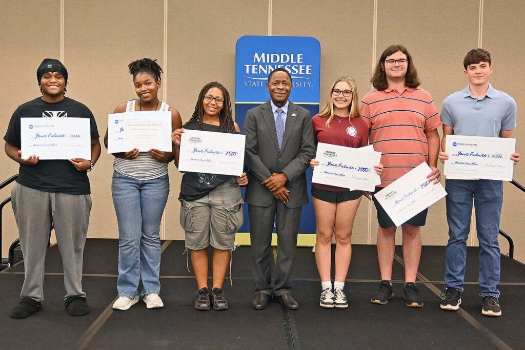Sidney A. McPhee, center, president of Middle Tennessee State University in Murfreesboro, Tenn., stands with scholarship winners at the True Blue Tour recruitment reception held on Wednesday, Oct. 14, at The Westin in Huntsville, Ala. A total of $7,500 was awarded to the six students whose names were drawn. (MTSU photo by Nancy DeGennaro)