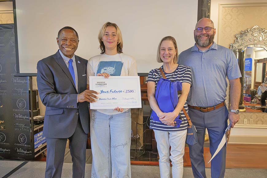 Middle Tennessee State University President Sidney A. McPhee, left, presents a scholarship to Elizabethton High School student Annabelle Light, who is flanked by her parents, Ellie and Jason Light, at the True Blue Tour student recruitment stop held at the historic Carnegie Hotel in Johnson City, Tenn., on Sept. 29, 2026. (MTSU photo by Nancy DeGennaro)