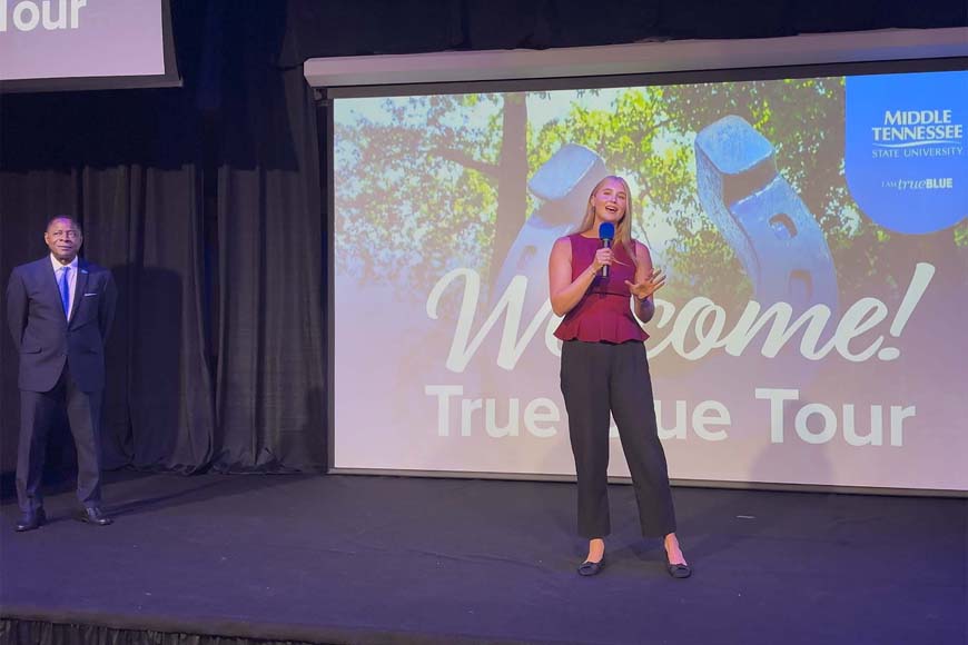 Taylor Pennington, a reporter with Knoxville, Tenn., NBC affiliate WBIR-TV, talks about her academic journey in the Scott Borchetta College of Media and Entertainment at Middle Tennessee State University in Murfreesboro, Tenn., with a crowd of students and their families during the True Blue Tour student recruitment stop at Bridgewater Place in Knoxville, Tenn., on Sept. 30, 2026. (MTSU photo by Nancy DeGennaro)