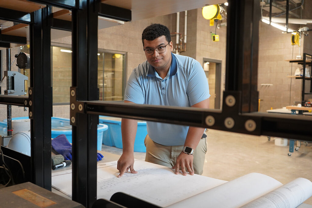 Middle Tennessee State University construction management major Lucas Daggs stands over plans for the McWherter Learning Resource Center in the School of Concrete and Construction Management Building on campus in Murfreesboro, Tenn. (MTSU photo by Robin E. Lee)