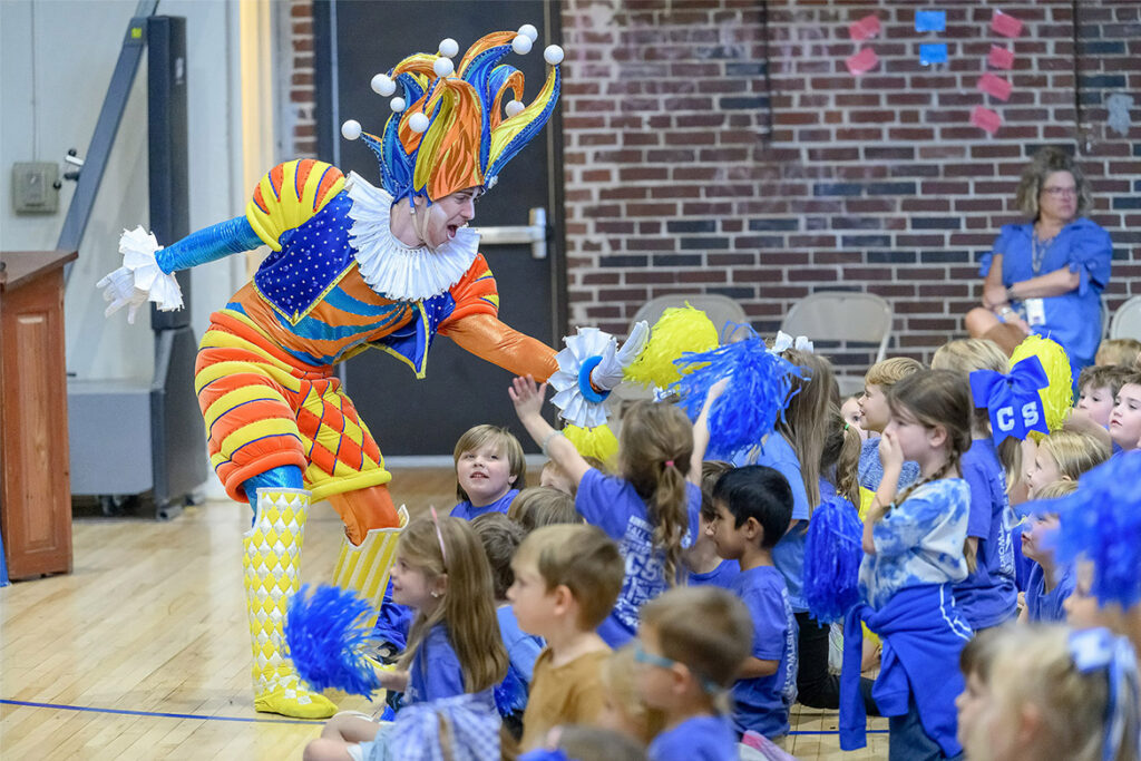 The character Cirqueumstance gives high-fives to students during a special holiday-themed literacy event on Oct. 22, 2026, at Homer Pittard Campus School in Murfreesboro, Tenn. The event was a partnership between Middle Tennessee State University’s College of Education and Gaylord Opryland Resort. (MTSU photo by J. Intintoli)