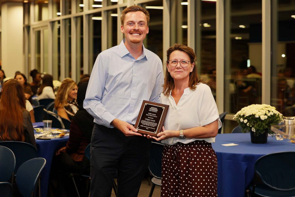 Angie Bowman, right, associate professor of public health in the Department of Health Sciences at Middle Tennessee State University in Murfreesboro, Tenn., presents the Early Career Award to Chipper Smith, Public Health Program lecturer and MTSU alumnus, at the annual Public Health Program PHamily Dinner held in September 2026. (Submitted photo)